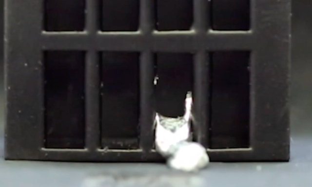 Fotograma de un video de un robot con forma de persona que se licua para escapar de una jaula, después de lo cual se extrae y se vuelve a moldear a su forma original.
