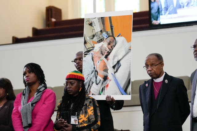 <p>Family members hold a photo of Tyre Nichols </p>