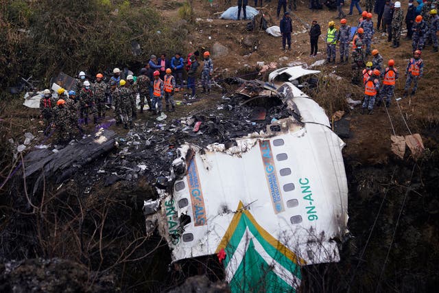 <p>Rescuers scour the crash site of a passenger plane in Pokhara, Nepal, Monday, 16 January 2023</p>
