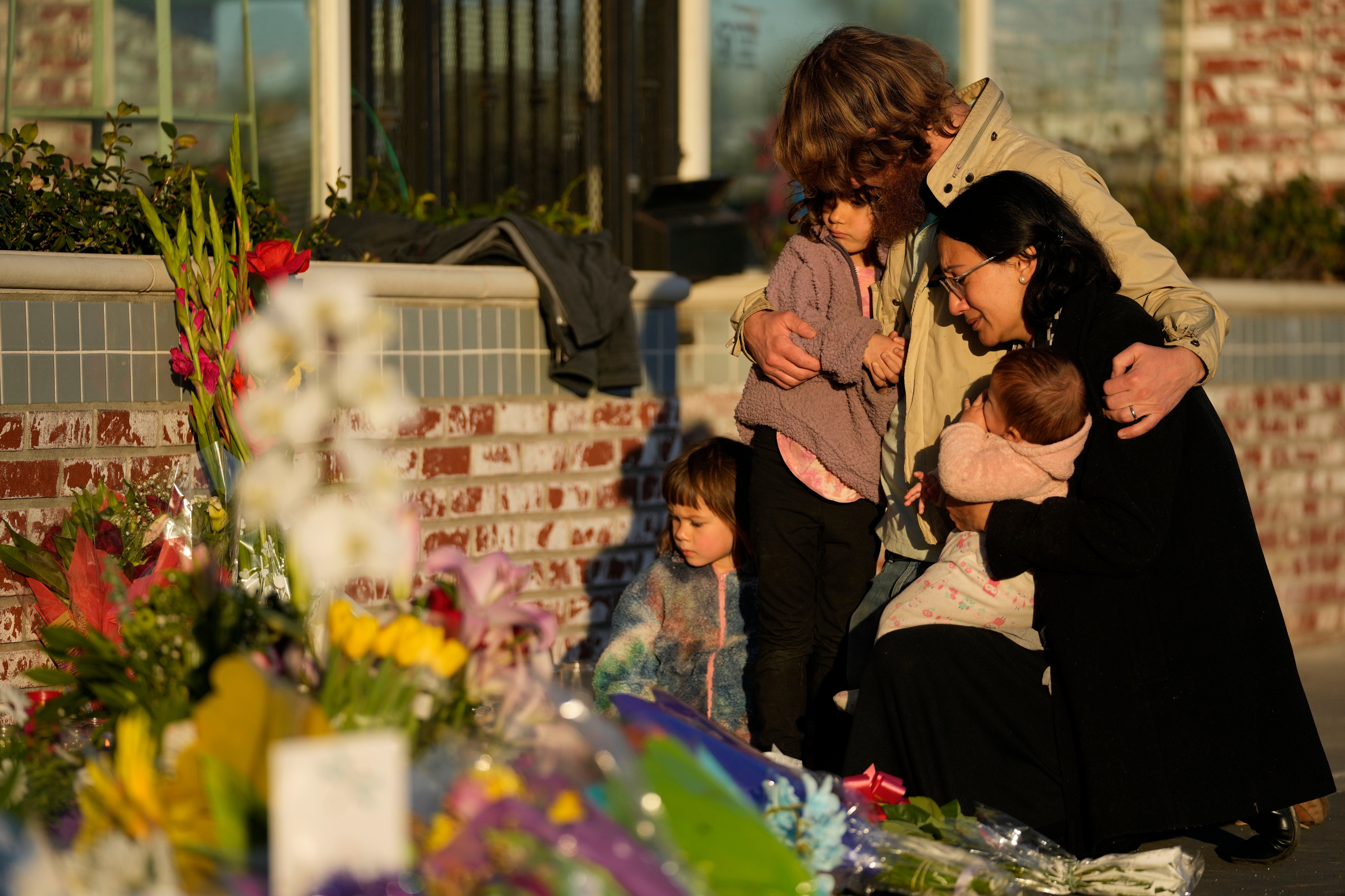 A family gathers at a memorial outside the Star Ballroom Dance Studio in Monterey Park