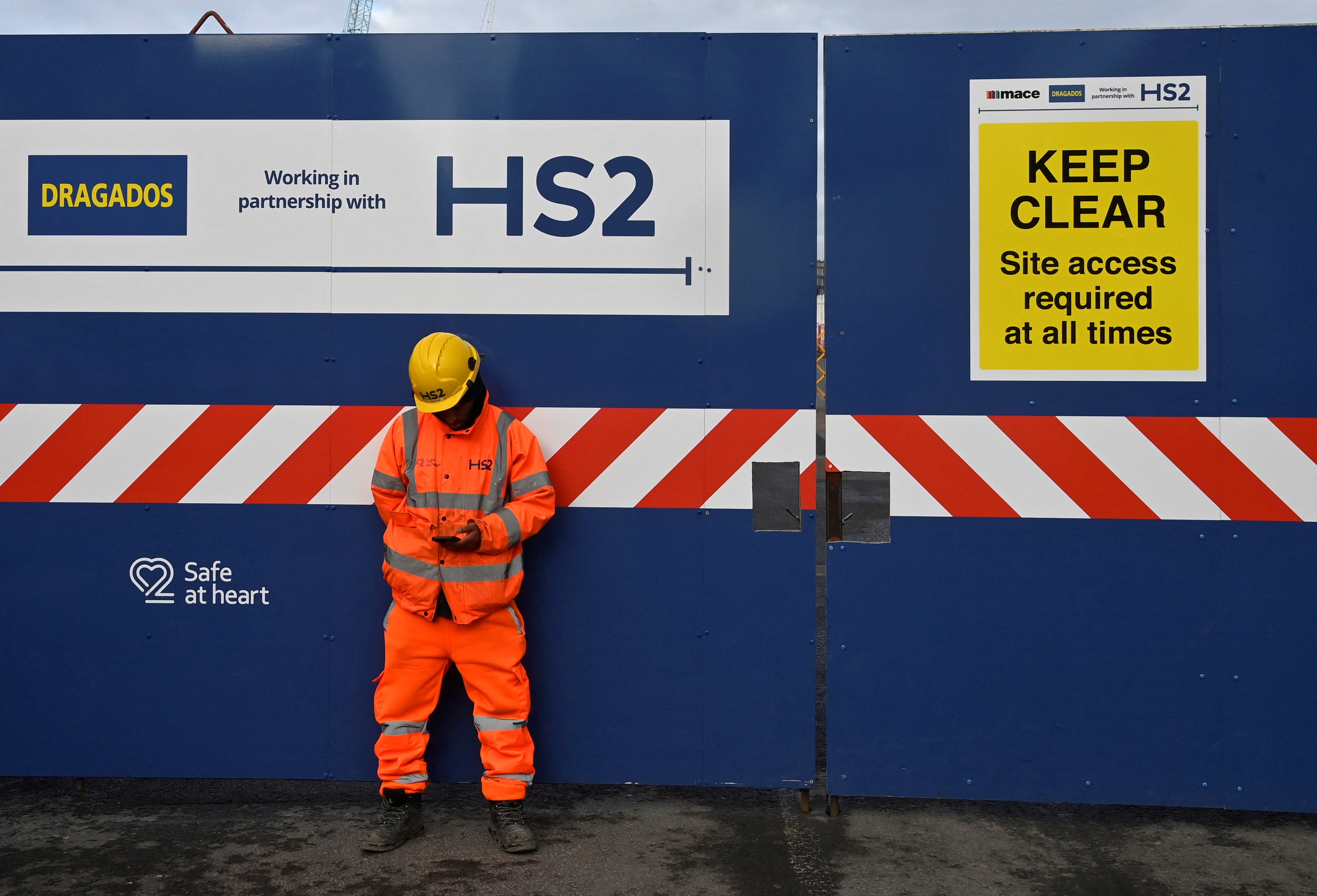 A worker stands at the entrance to an HS2 high-speed rail construction site at Euston in London