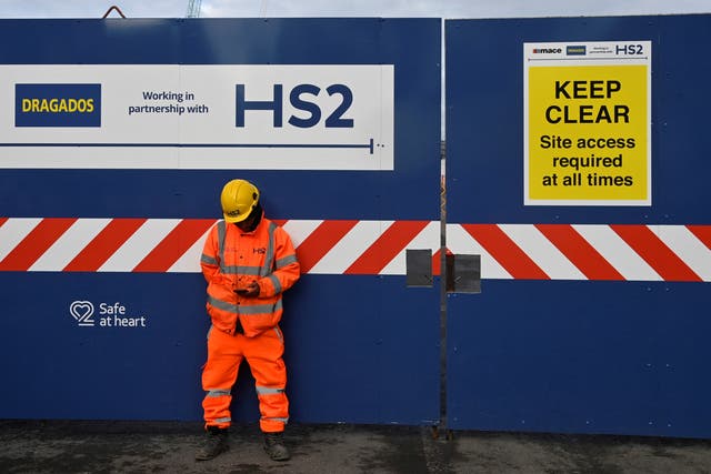 <p>A worker stands at the entrance to an HS2 high-speed rail construction site at Euston in London</p>