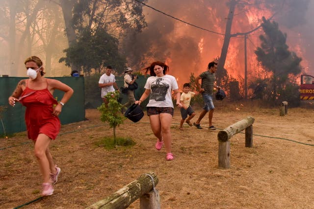 <p>People run from flames during fire in La Floresta, Uruguay</p>