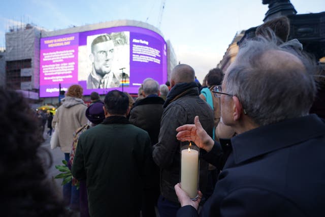 Dr Martin Stern, a survivor of the Holocaust, holds a candle at Piccadilly Circus (James Manning/PA)