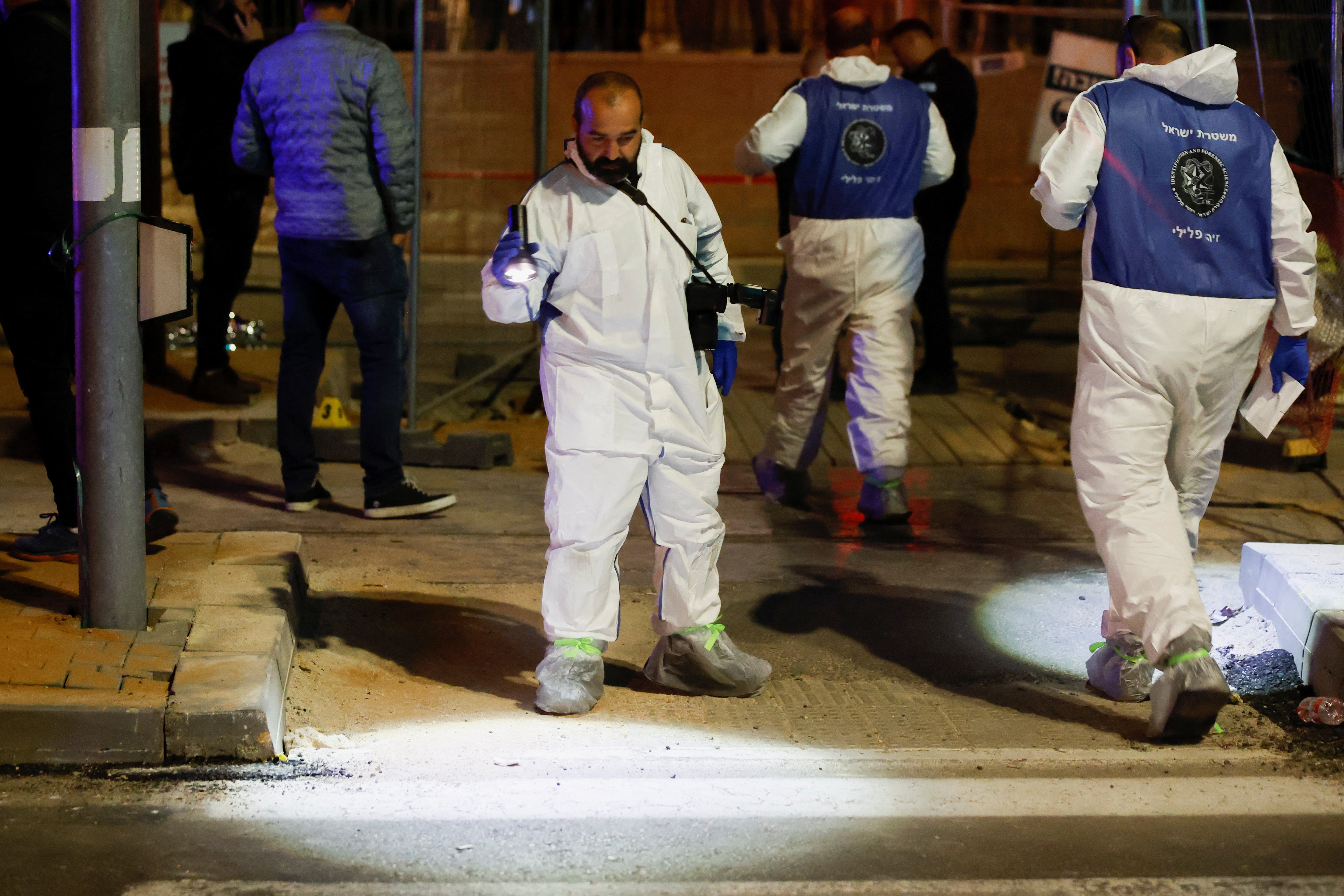 Forensic team members work at the scene of the shooting