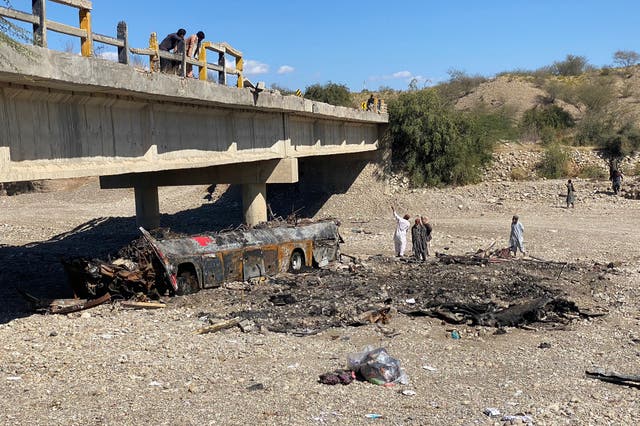 <p>Residents look at the wreckage of a burnt passenger bus at Bela in Lasbela district of Pakistan’s Balochistan province</p>