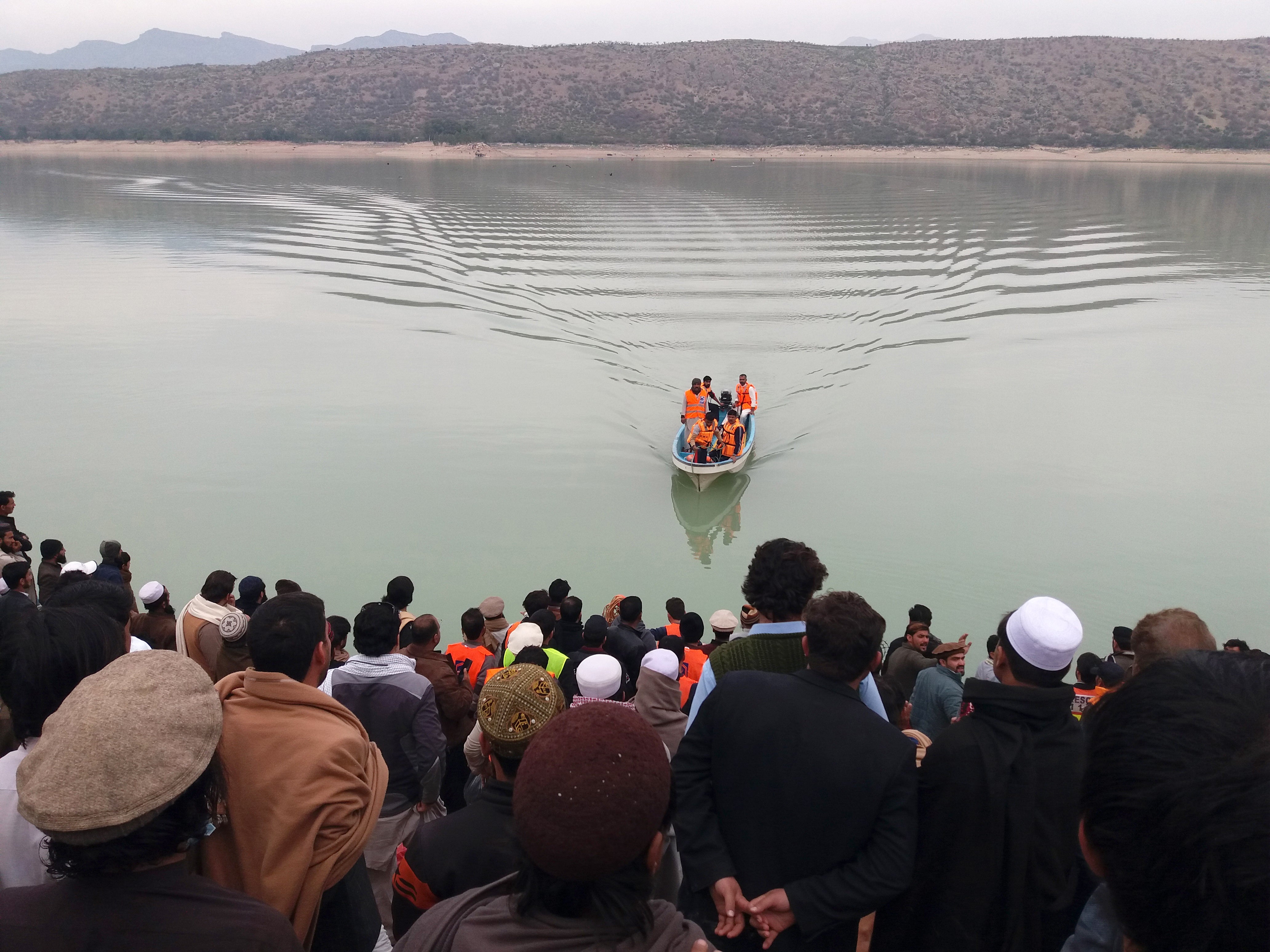 Rescue workers perform a search operation for bodies after a boat capsized in Kohat dam, Pakistan