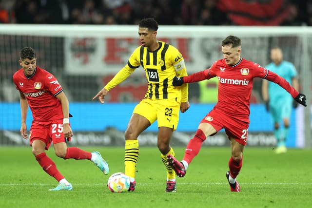 <p> Jude Bellingham of Borussia Dortmund is challenged by Florian Wirtz of Bayer 04 Leverkusen</p>