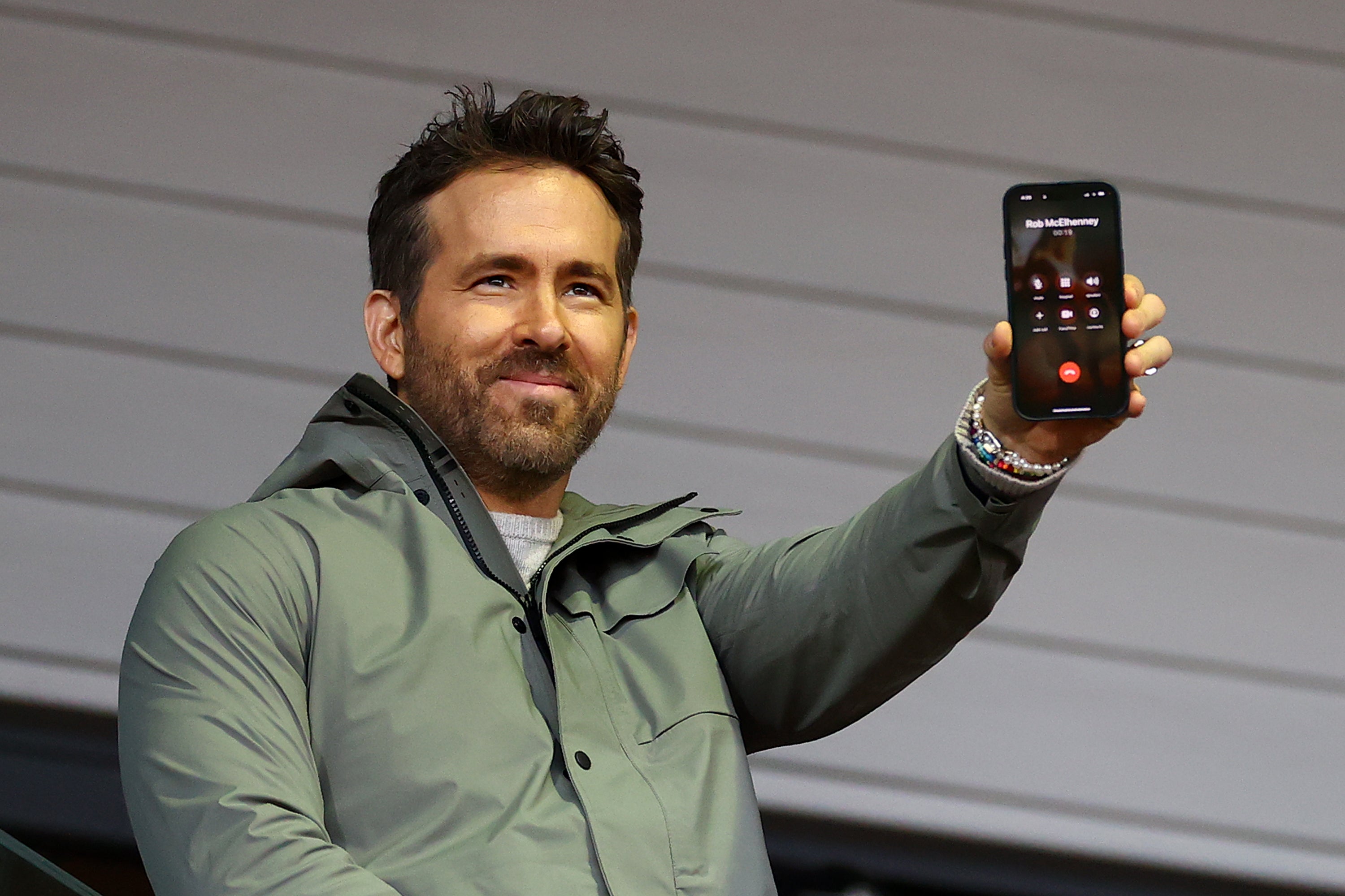 Ryan Reynolds speaks to Rob McElhenney, fellow co-owner of Wrexham, on the phone during the match