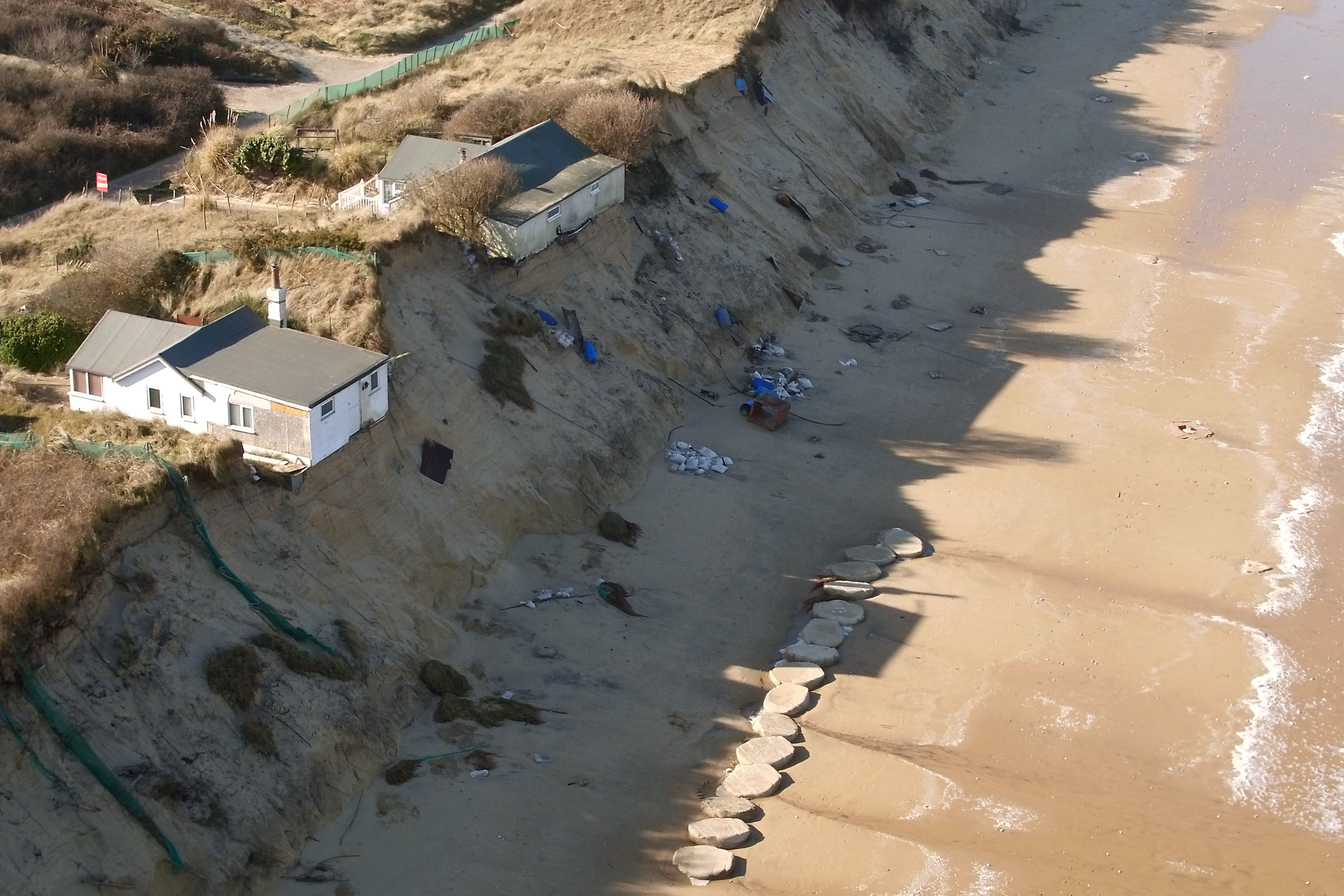Houses sit on the cliff edge on The Marrams in Hemsby, Norfolk where parts of the cliff have collapsed into the sea