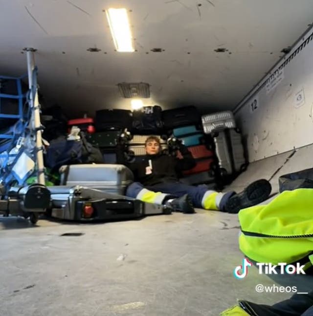 <p>The airport baggage handler poses in front of the first haul of bags</p>