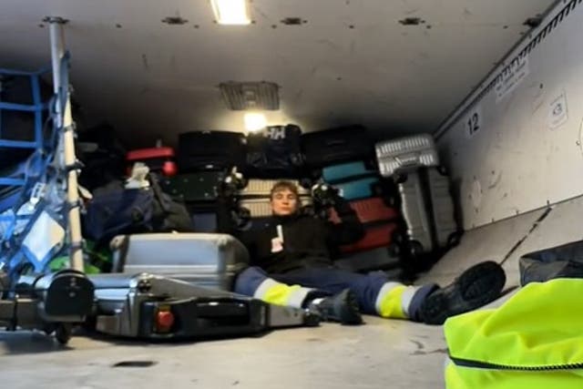 <p>The airport baggage handler poses in front of the first haul of bags</p>
