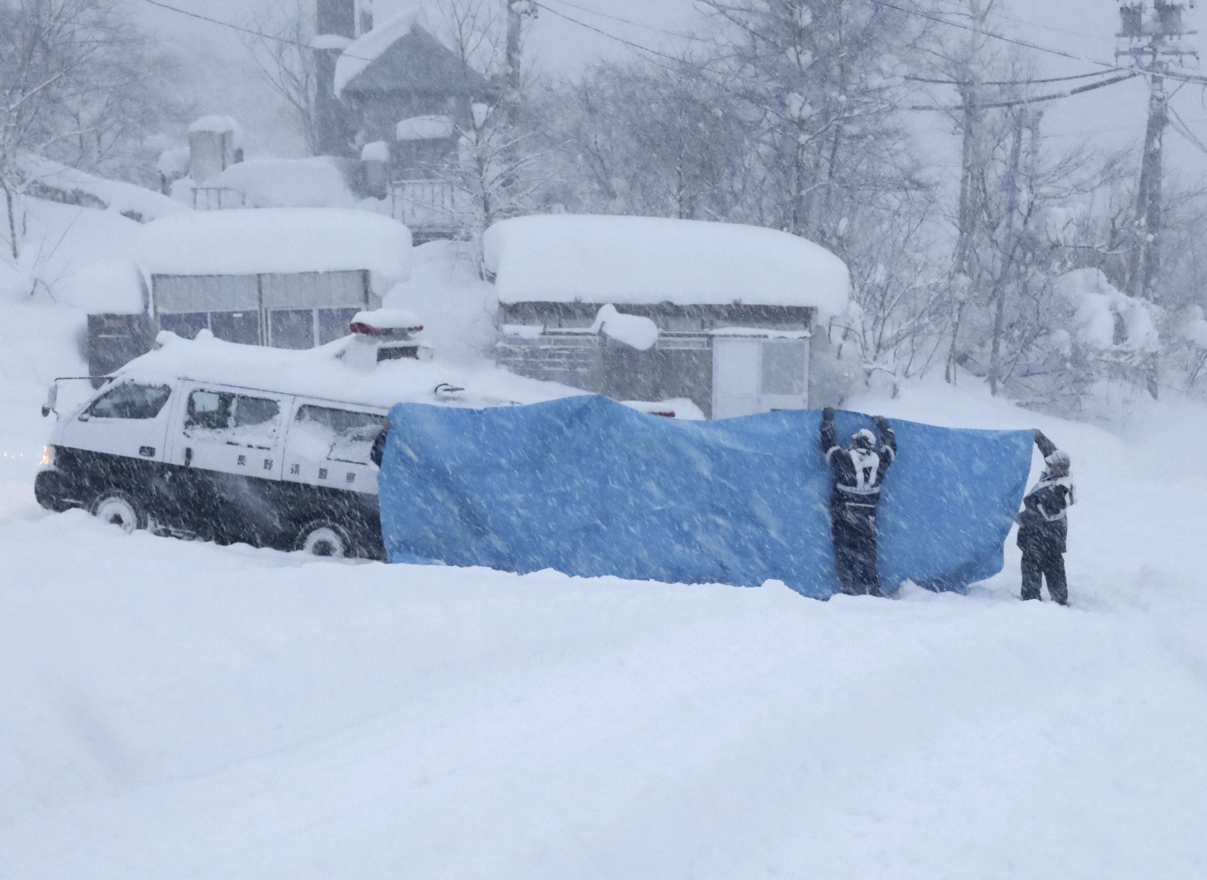 File - Rescue crews work to recover bodies after an avalanche