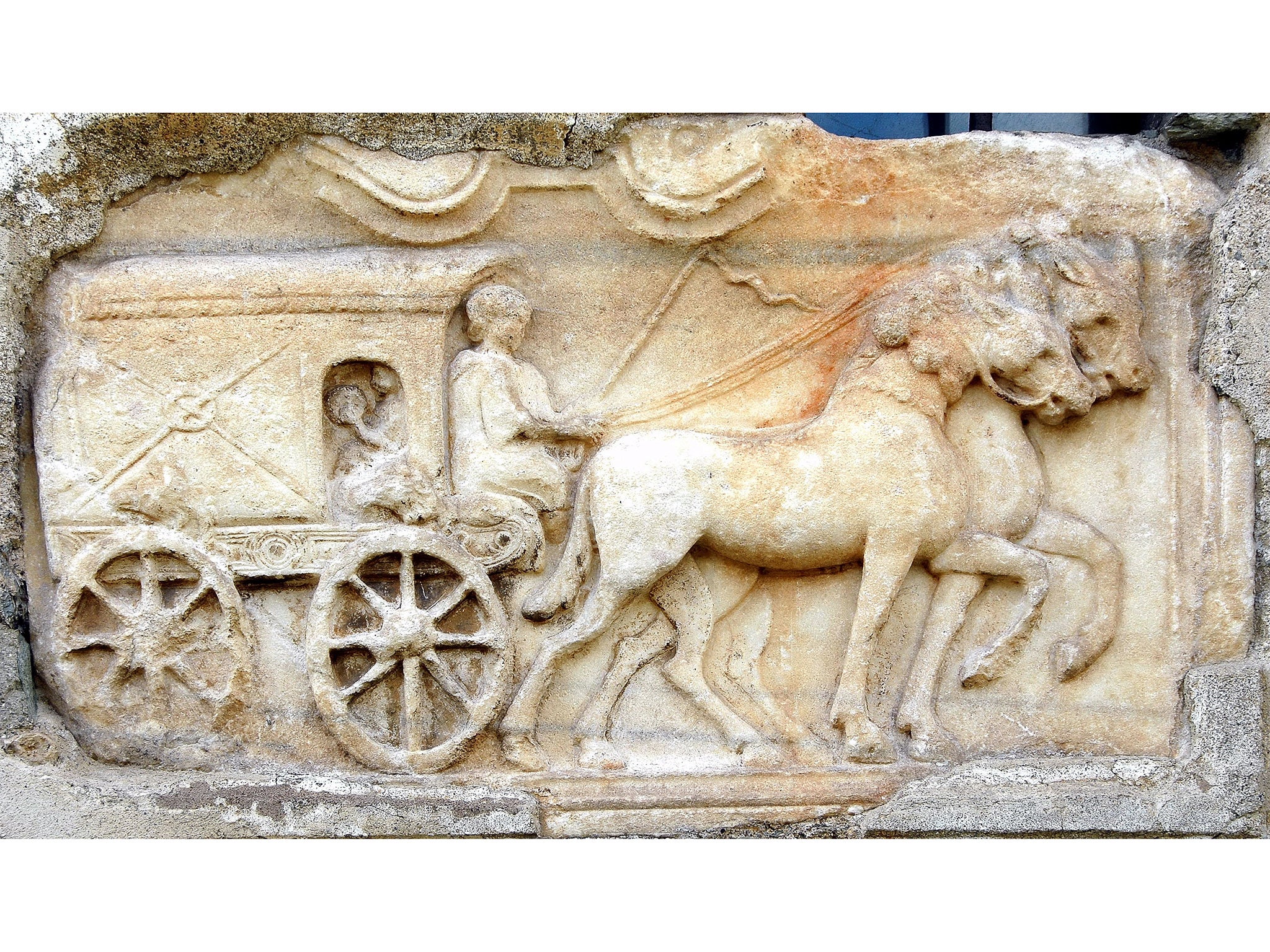 Covered Wagon relief from a Roman tombstone now in the church wall of Maria Saal, Klagenfurt, Austria. Edited copy of a photograph