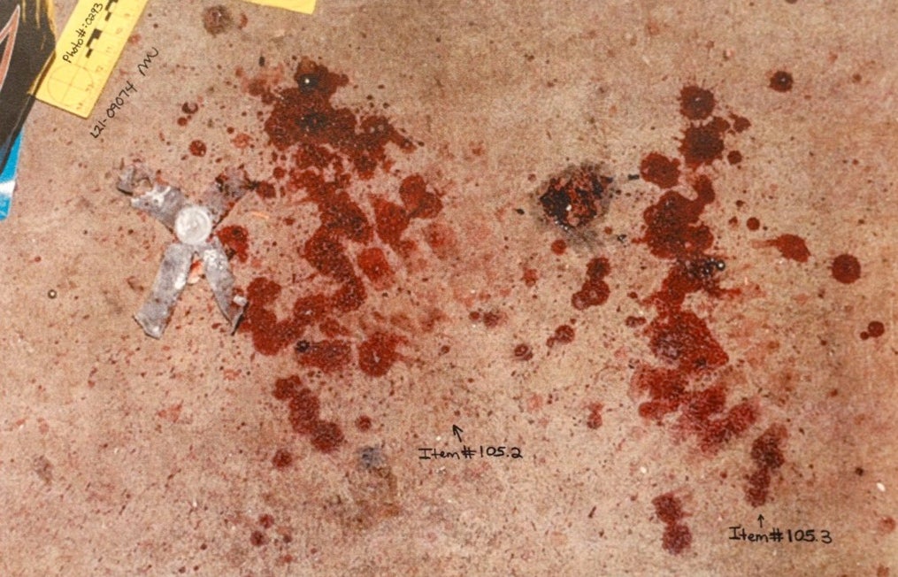 Crime scene photos show blood on the floor of the dog feed house