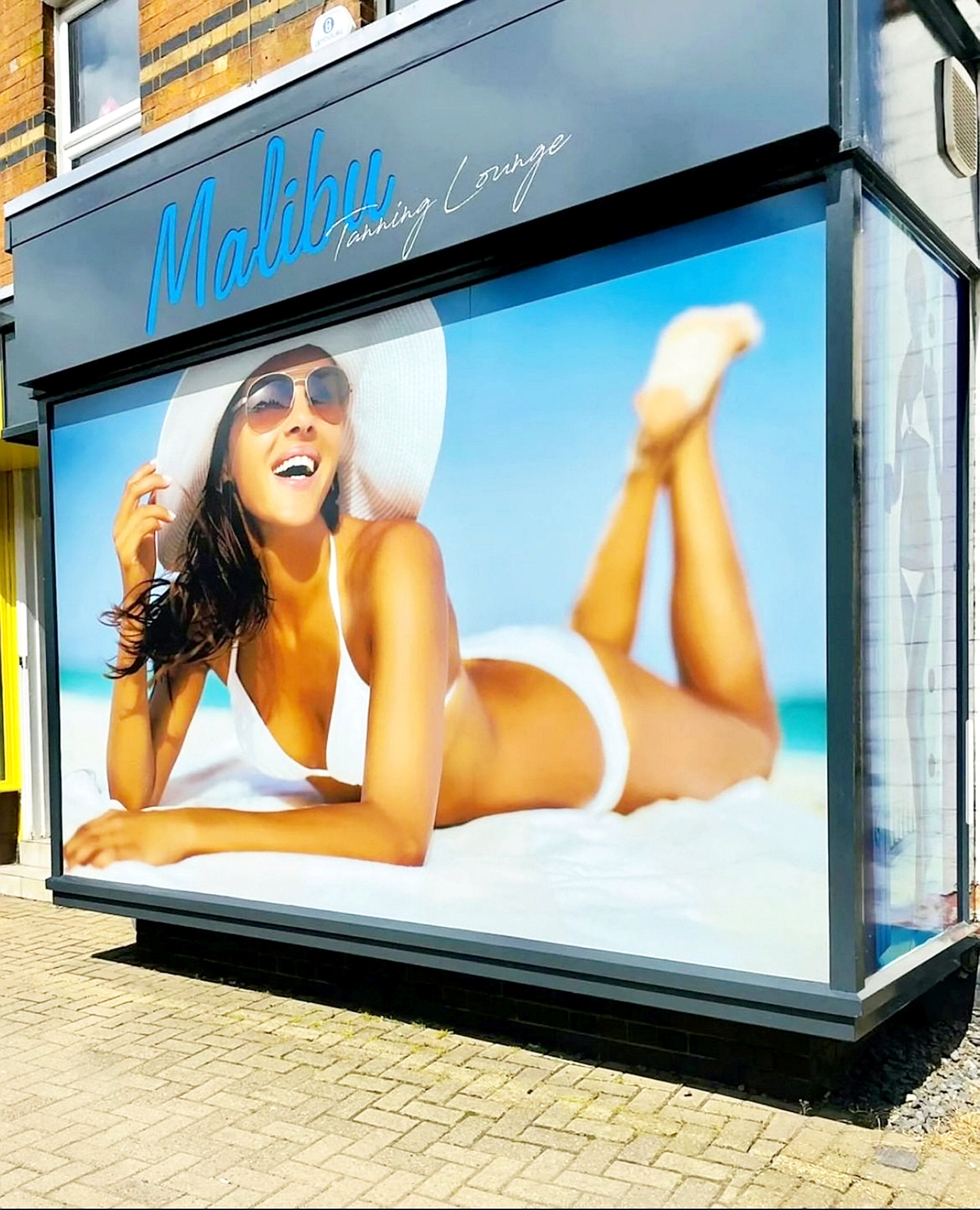 A tanning salon has been ordered to remove an 'offensive' shop front display of a sunbathing woman because it's not in keeping with the image of a historic market town