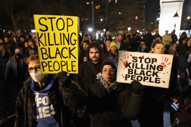 <p>Demonstrators hold signs during a protest at Washington Square Park in New York on 28 January 2023, in response to the death of Tyre Nichols, who died after being beaten by Memphis police during a traffic stop</p>