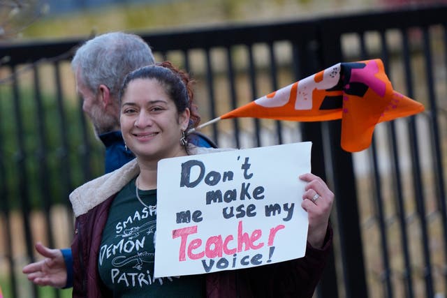<p>Teachers hold flags and placards on a picketline outside Holland Park School as they go on strike over pay in London</p>