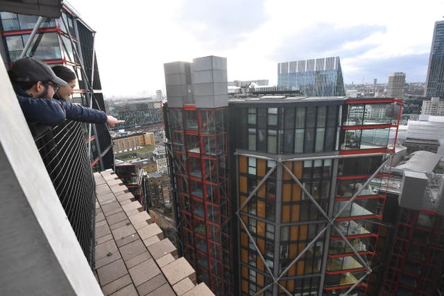 <p>People look out from the viewing platform at Tate Modern, left, which overlooks the residential flats</p>