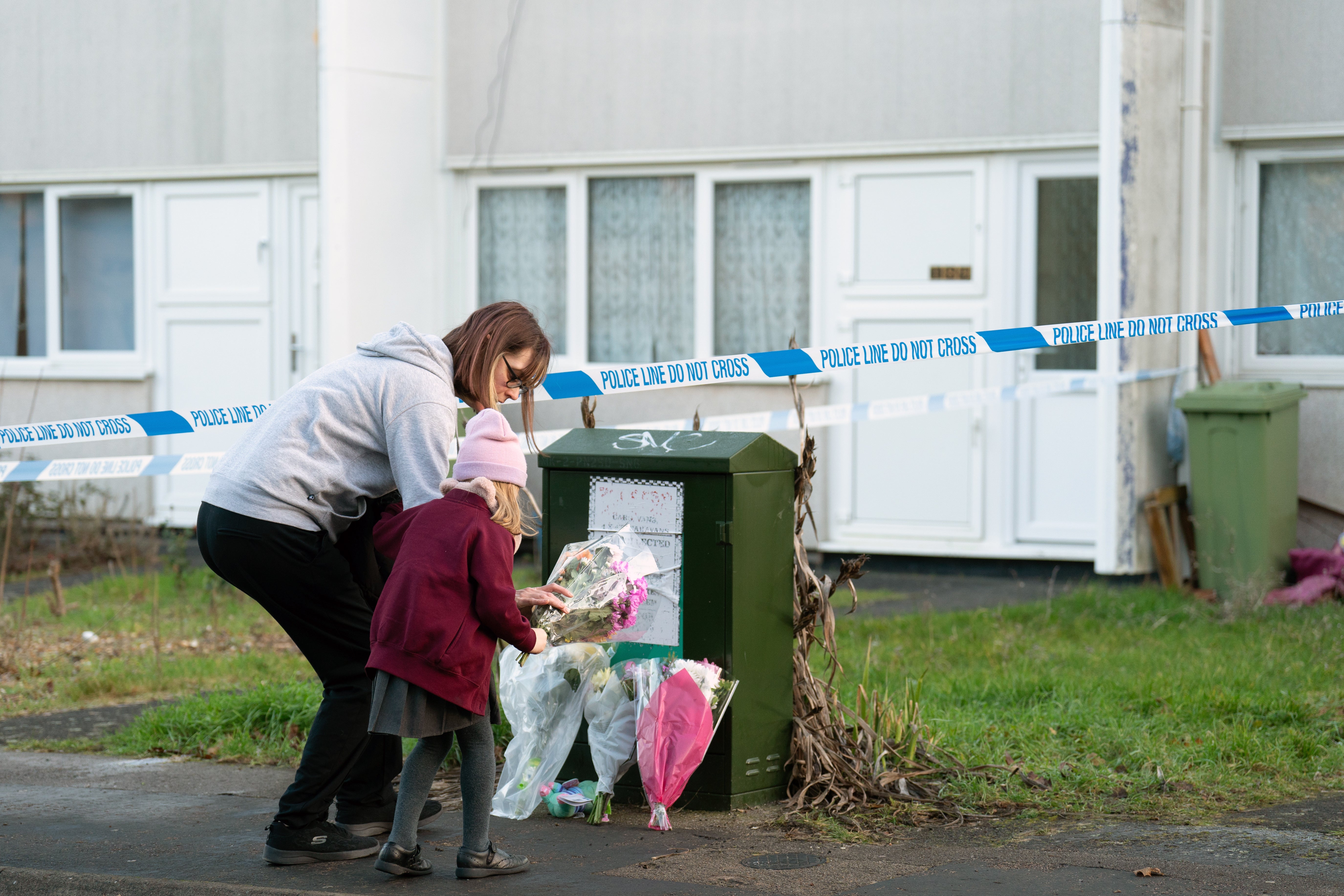 A woman and child arrive to leave flowers at the scene on Broadlands, Netherfield, Milton Keynes, Buckinghamshire