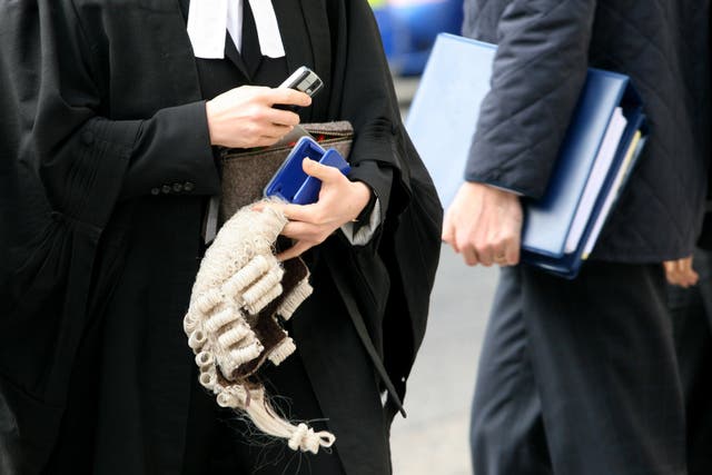 A barrister carries a wig (Katie Collins/PA)