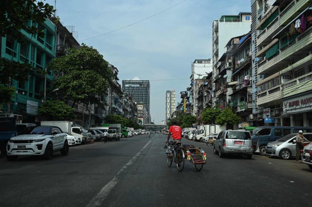 <p>A man rides his trishaw on an almost empty street during a ‘silent strike’ to protest and mark the second anniversary of the military coup in Myanmar </p>