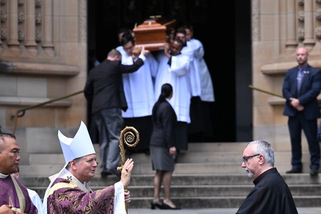 <p>Archbishop of Sydney Anthony Fisher gives a blessing as the casket of Cardinal George Pell is carried</p>