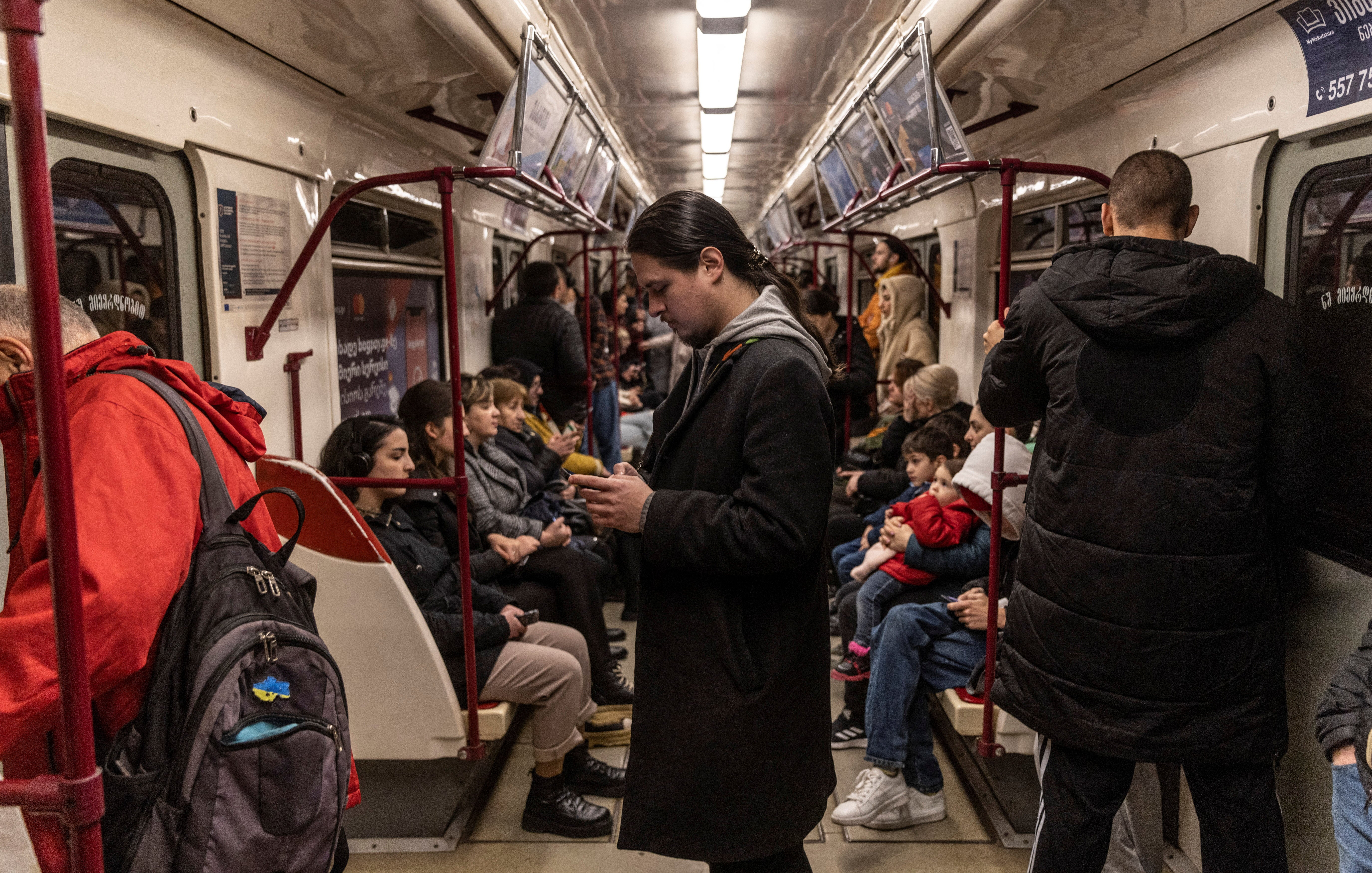Antropov looks at his phone in the subway