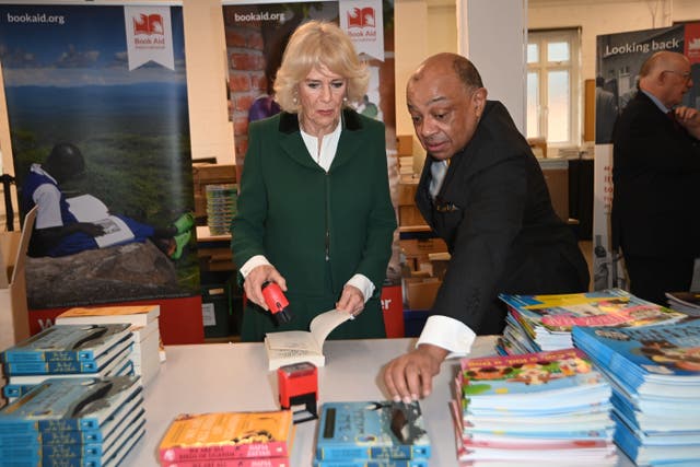 Camilla stamped a book ready for export to Africa during her visit to Book Aid International (Eddie Mulholland/Daily Telegraph/PA)