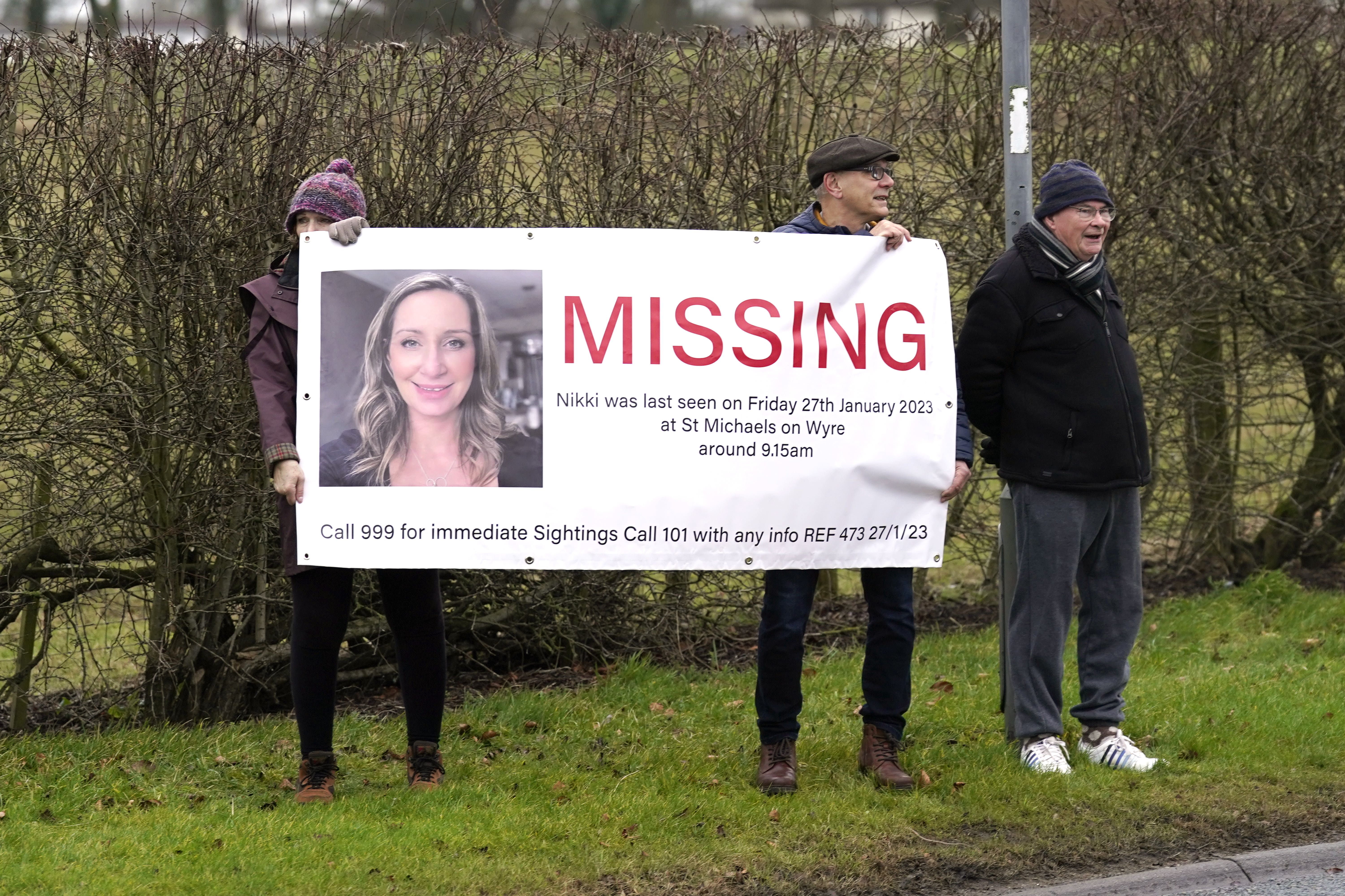 Members of the public line the road into St Michael’s on Wyre, Lancashire, with missing posters of Nicola Bulley (Danny Lawson/PA)