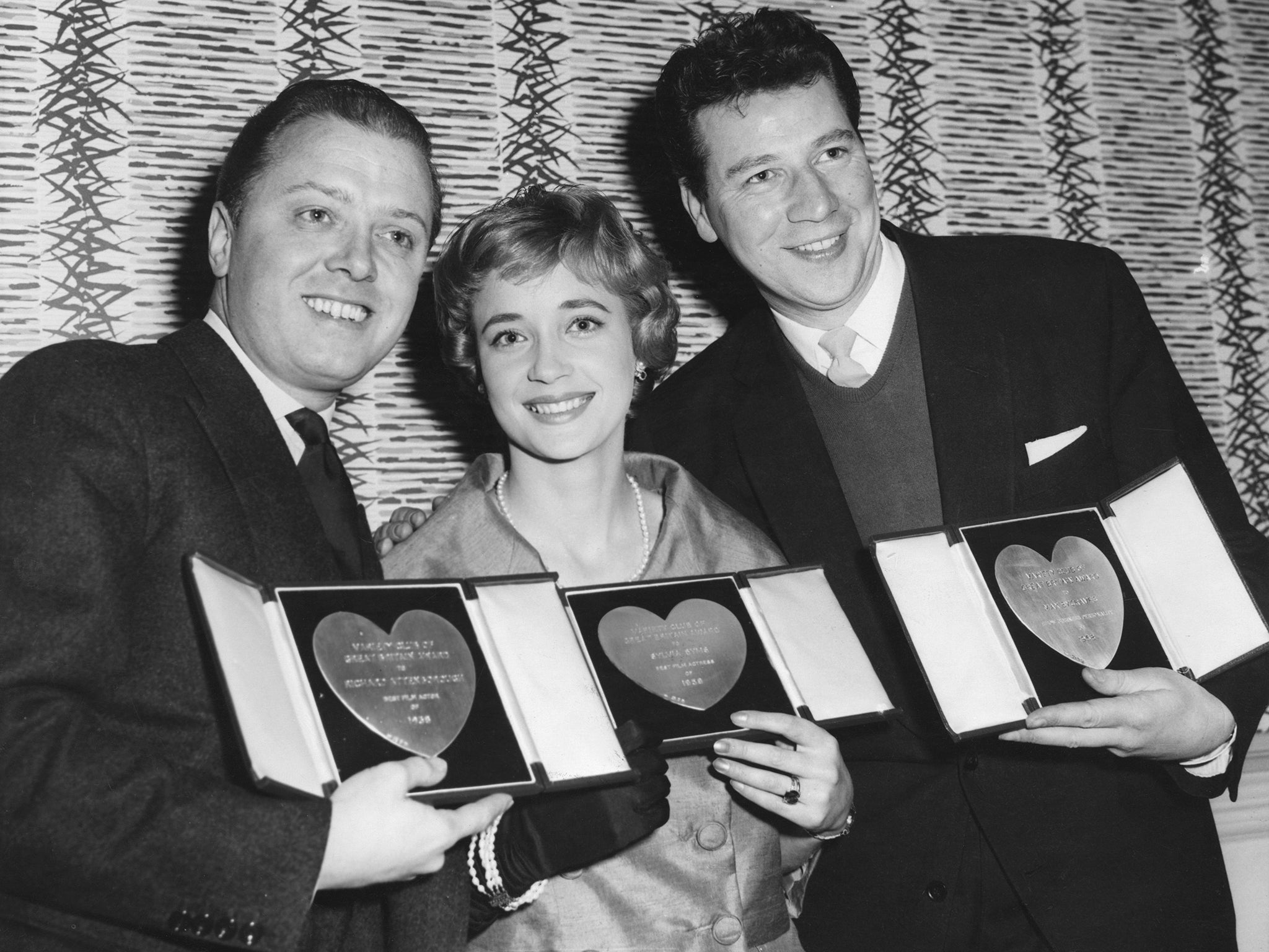 From left to right, actors Richard Attenborough, Sylvia Syms and Max Bygraves with their awards at the Variety Club Luncheon in March 1959