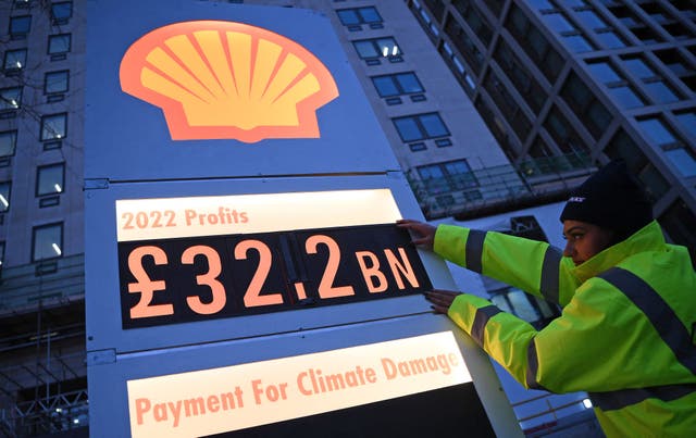 <p>Activists from Greenpeace set up a mock-petrol station price board displaying the company's net profit for 2022, as they demonstrate outside the headquarters of Shell, in London</p>