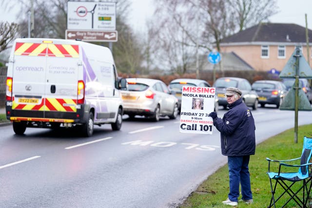 <p>A member of the public lines the road into St Michael’s on Wyre, Lancashire, with missing posters of Nicola Bulley, 45, as police continue their search for the missing woman who was last seen on the morning of Friday January 27, when she was spotted walking her dog on a footpath by the nearby River Wyre</p>