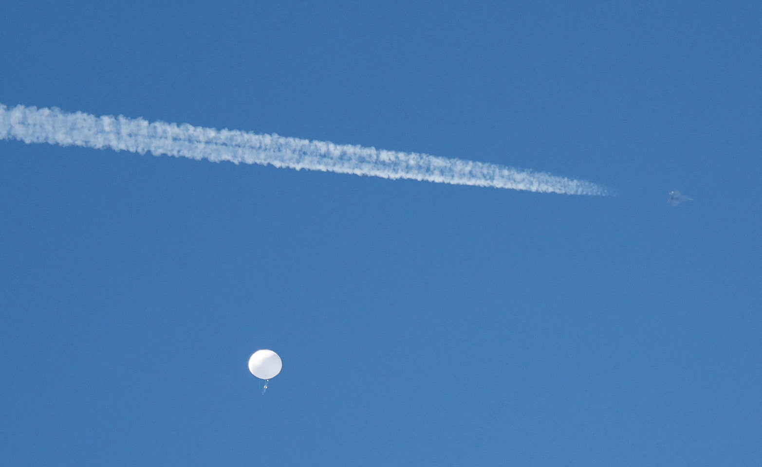 <p>A jet flies by a suspected Chinese spy balloon as it floats off the coast in Surfside Beach</p>
