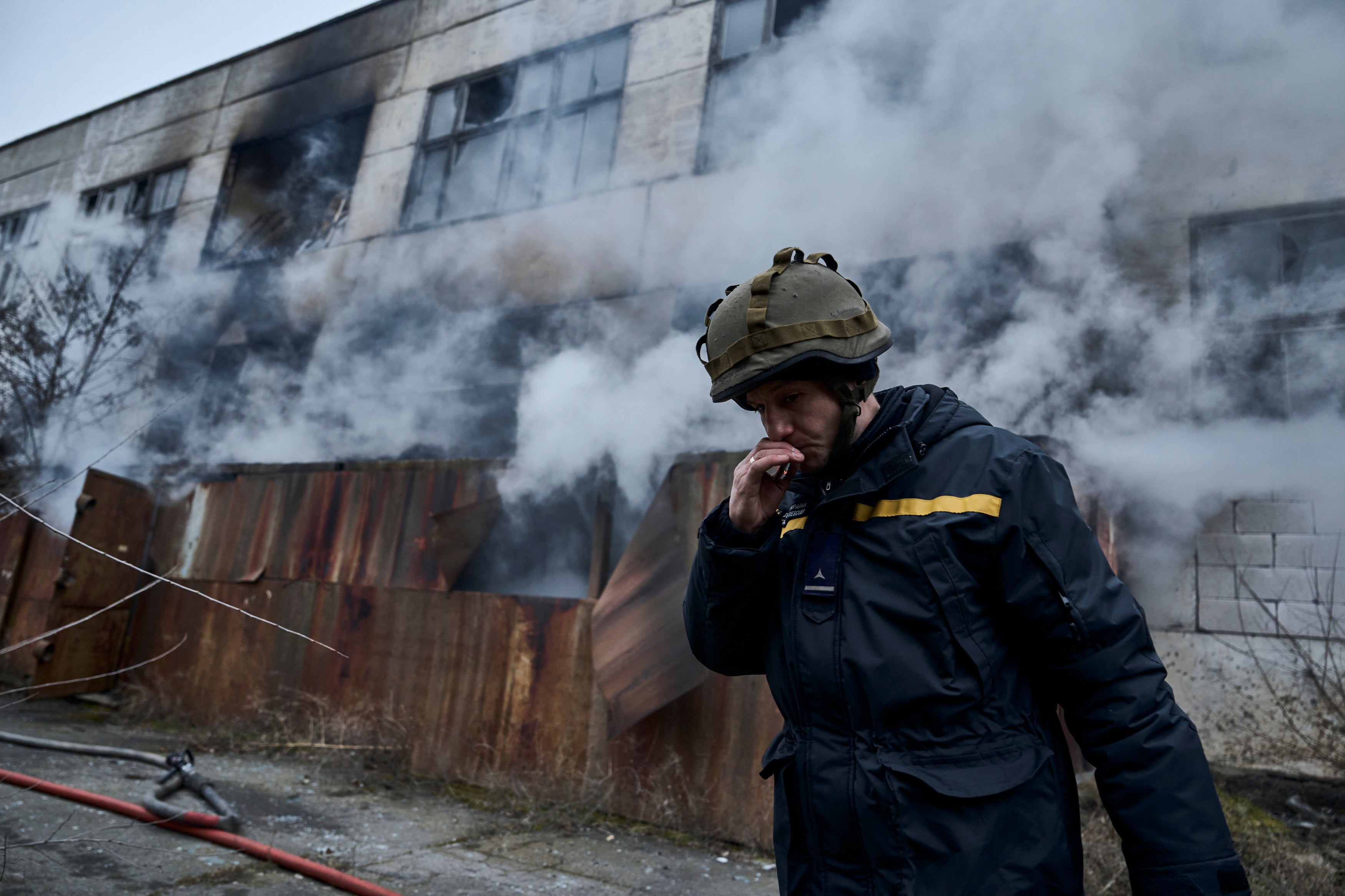 A Ukrainian firefighter takes a break following Russian shelling that hit an industrial area in Kherson