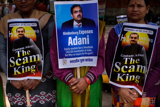 <p>Members of opposition Congress party, demanding an investigation into allegations of fraud and stock manipulation by India's Adani Group hold placards with images of Indian businessman Gautam Adani</p>