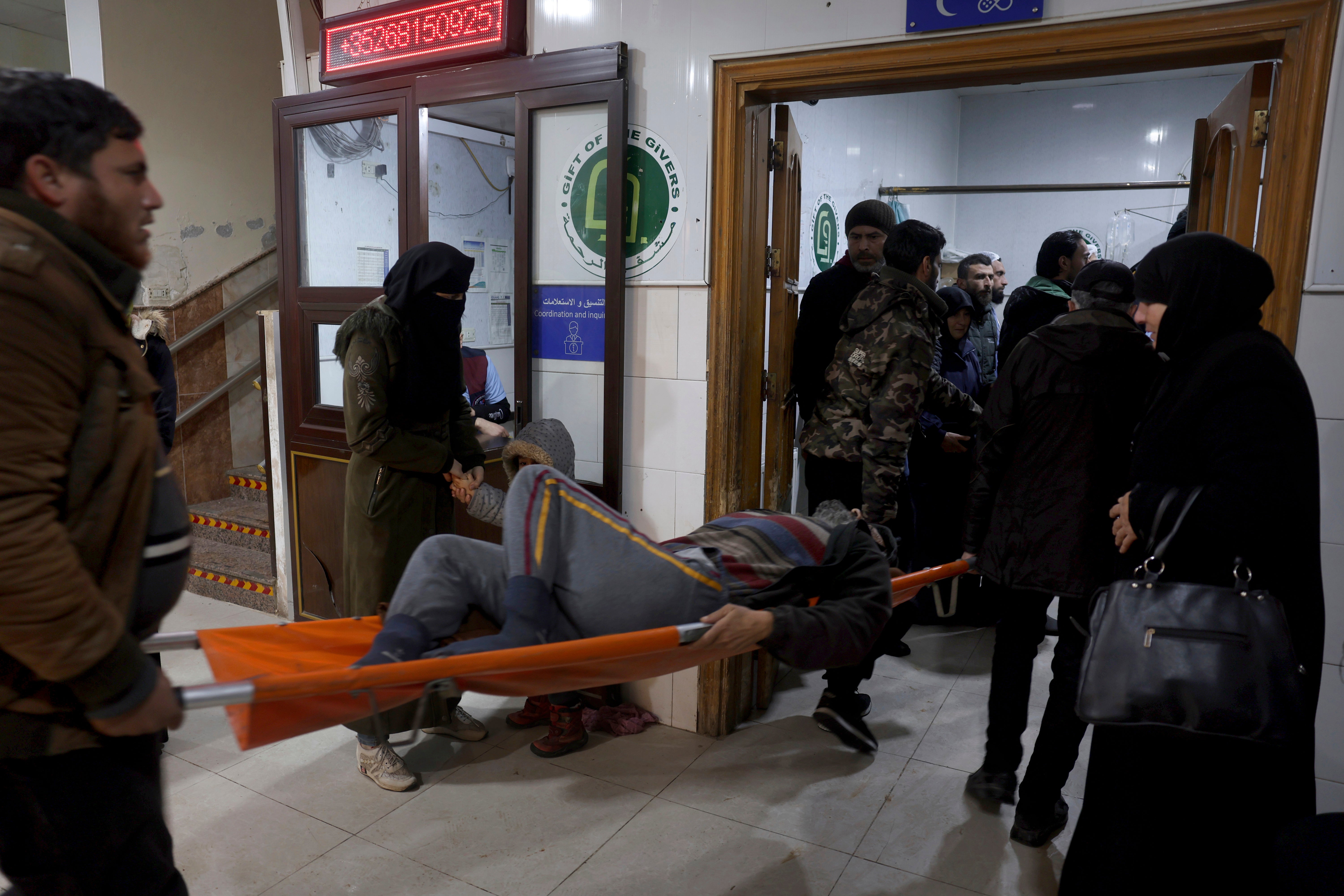A man injured in the quake is carried into the al-Rahma hospital in Darkush, Idlib province