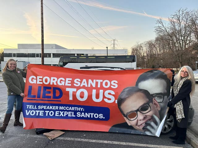 <p>Members of the ‘Concerned Citizens of NY-03’ group reveal a banner slamming George Santos</p>