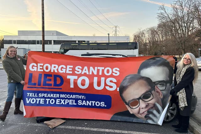 <p>Members of the ‘Concerned Citizens of NY-03’ group reveal a banner slamming George Santos</p>