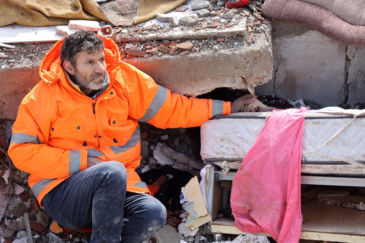 Heartbreaking photos show father clutching hand of dead daughter following quakes