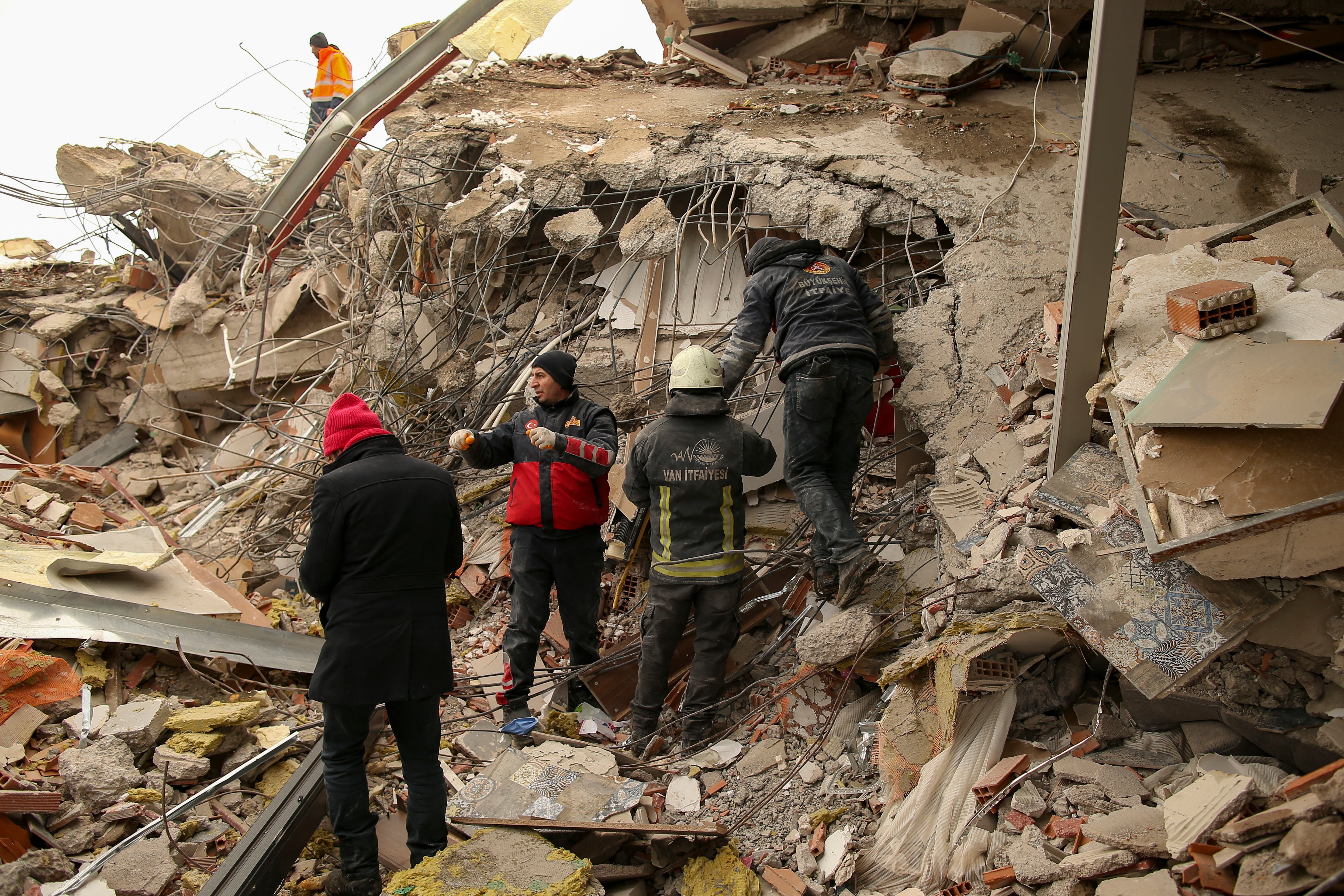 Rescue workers search for survivors on a collapsed building in Malatya, Turkey, Tuesday, Feb. 7, 2023.