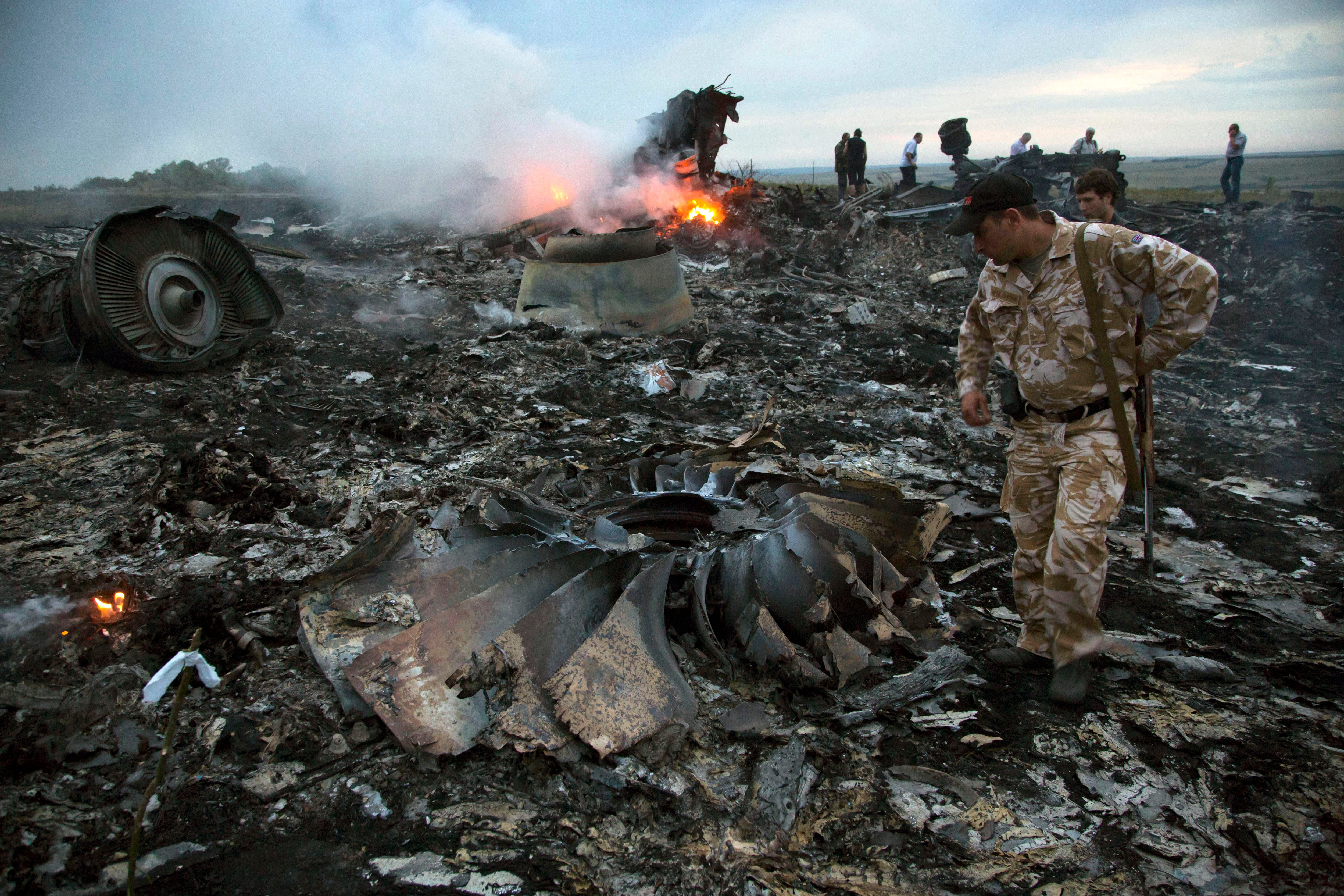 A man walks among the debris at the crash site near the village of Hrabove, in Ukraine