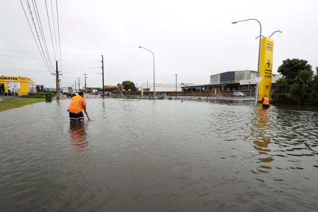 <p>Workers try to survey the ground under flood water in Auckland, New Zealand</p>