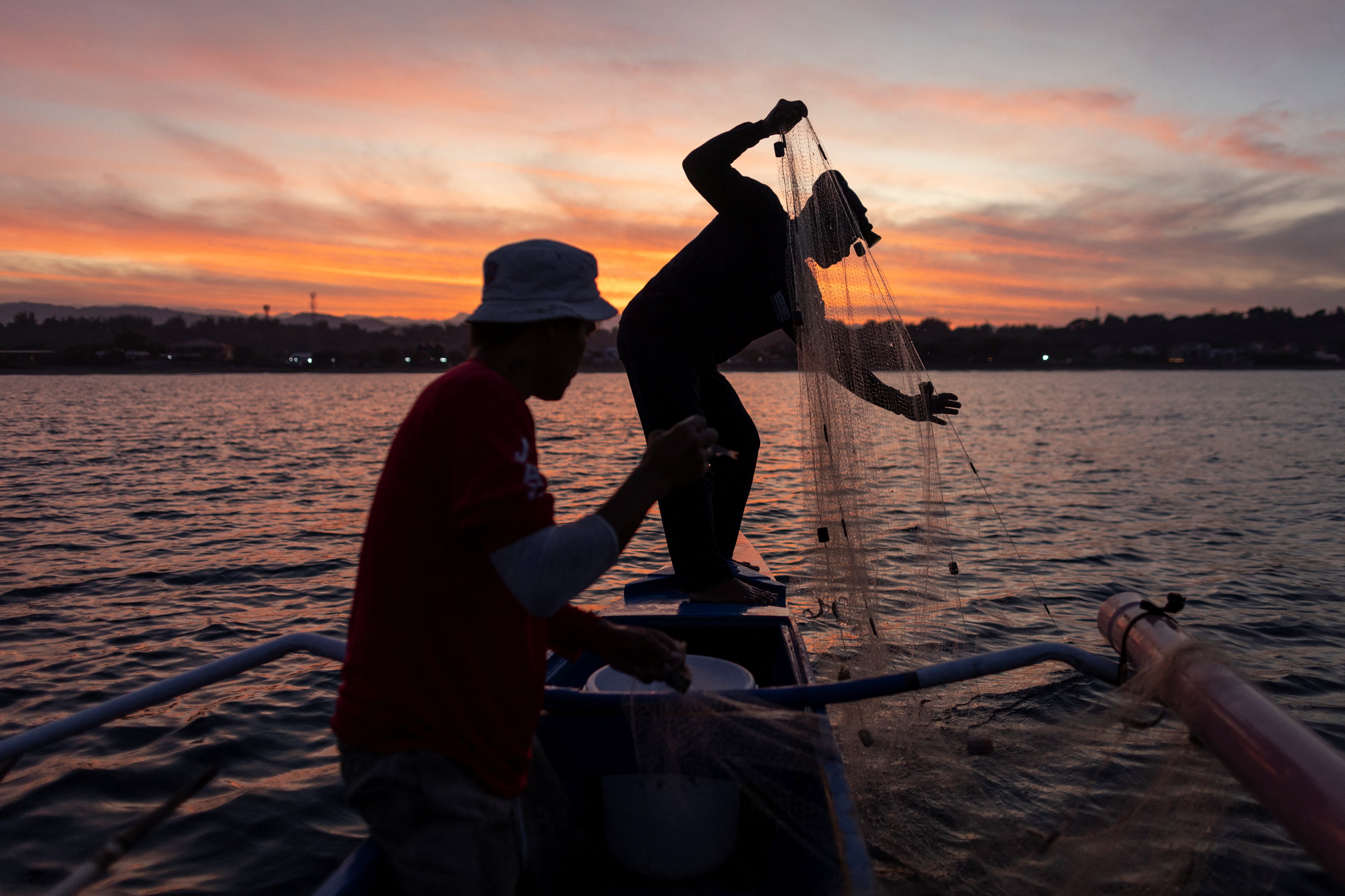 Jessie hauls his fishing net on his boat in Bacnotan, La Union