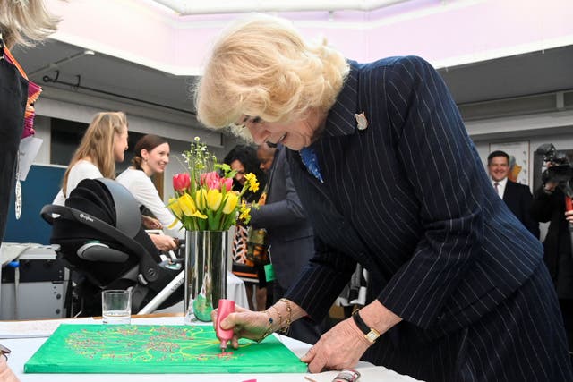 The Queen Consort helps to finish a painting(Toby Melville/PA)