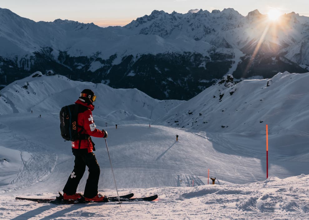 Ski patrol checking avalanche conditions in the Swiss Alps โ mountain hazards are the main safety concern, not crime