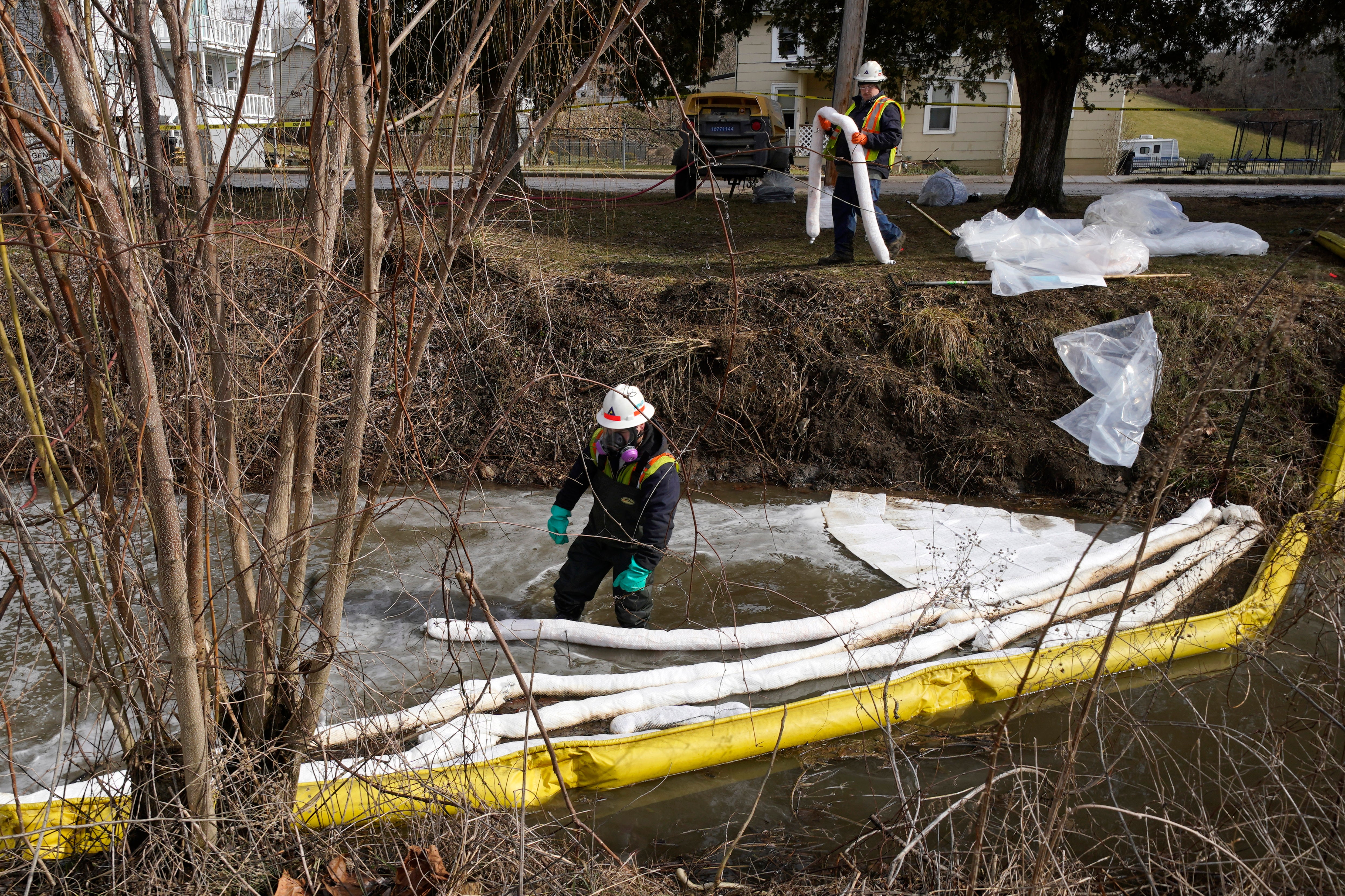 Contamination crews place booms in a stream in East Palestine, Ohio on Thursday as the cleanup continues after the derailment of a Norfolk Southern freight train