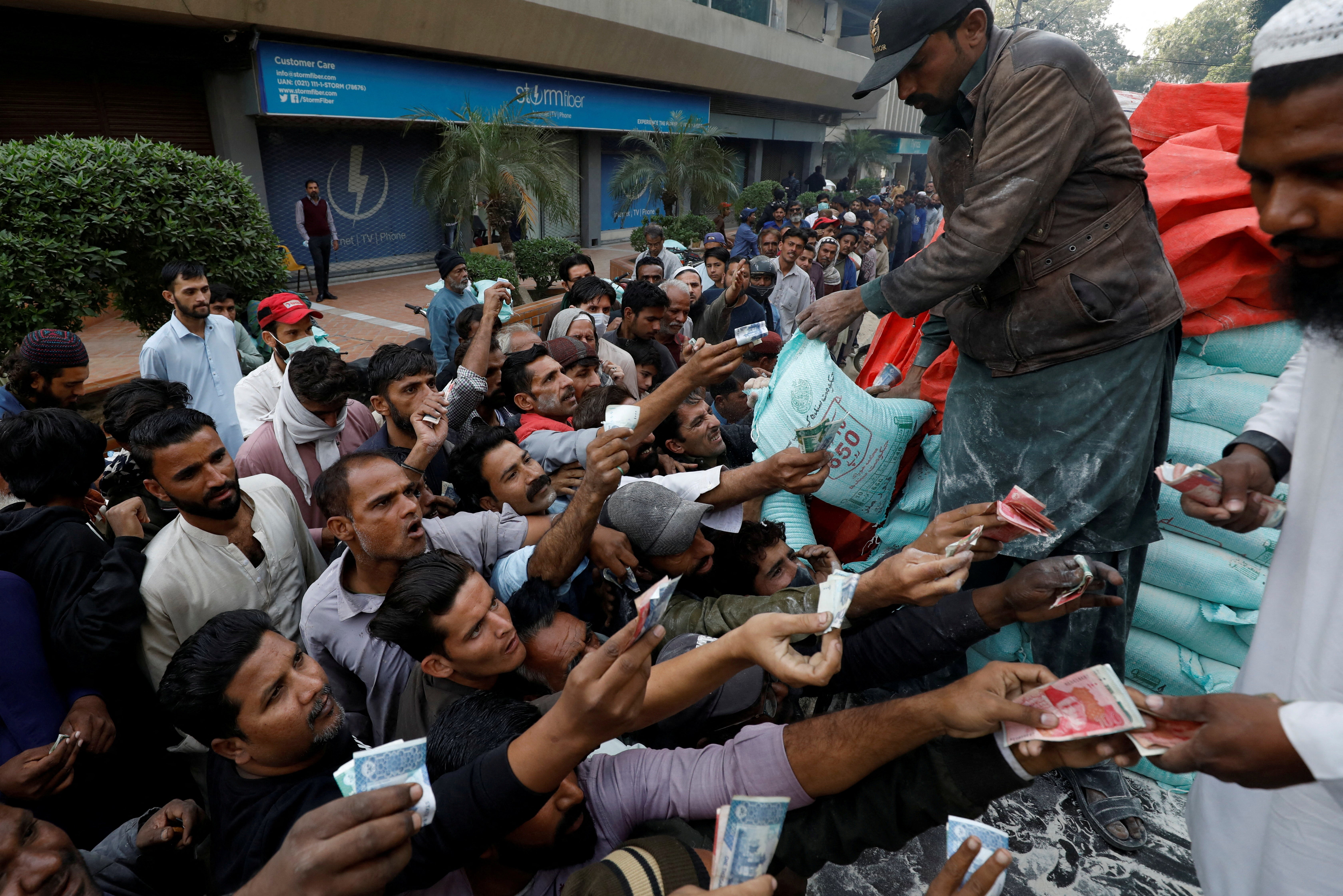 File photo: Men reach out to buy subsidised flour sacks from a truck in Karachi, Pakistan