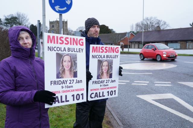 Friends of Nicola Bulley hold appeal posters along the main road in the village of St Michael’s on Wyre (Owen Humphreys/PA)