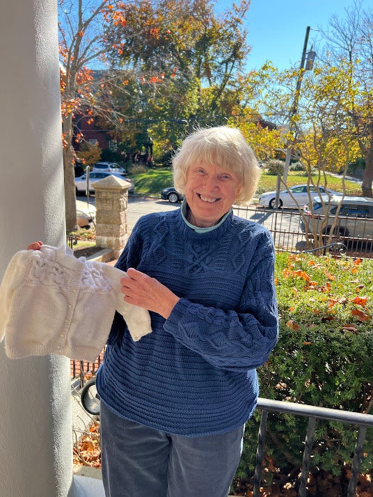 Volunteer finisher Sarah deDoes with the garment she completed for Annie’s family